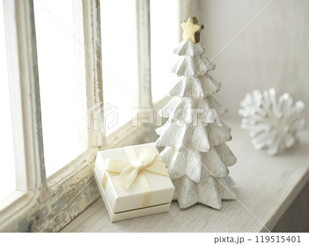明るい窓辺に置かれたクリスマスツリーとプレゼントボックス 明るい窓辺に置かれたクリスマスツリーとプレゼントボックス 119515401