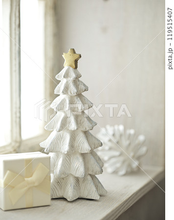 明るい窓辺に置かれたクリスマスツリーとプレゼントボックス 119515407