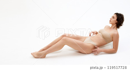 Relax and rejuvenate. Model's toned body and flawless skin speak of soothing spa experience against white studio background. 119517728