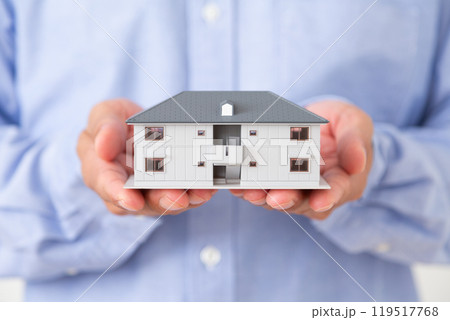 マンションの住宅模型を持つミドル男性 119517768