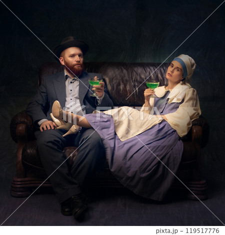 Vintage couple relaxing with drink. Man and woman relaxing on leather couch and drinking alcohol drinks Vintage couple relaxing with drink. Man and woman relaxing on leather couch and drinking alcohol drinks 119517776