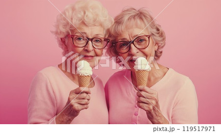 Elderly women eat ice cream cones on a pink background 119517971
