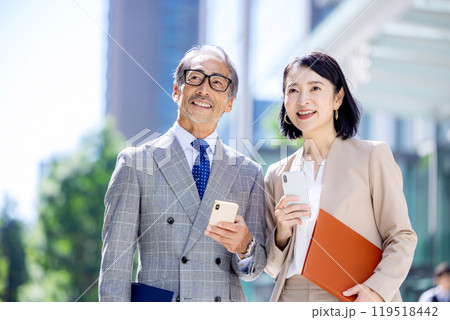 スマホを持つオフィス街のシニアサラリーマン 119518442