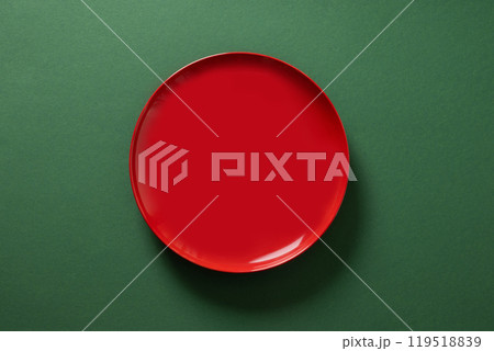 Red empty plate on green background. Christmas table setting. Xmas festive dinner concept. Top view. Copy space. 119518839