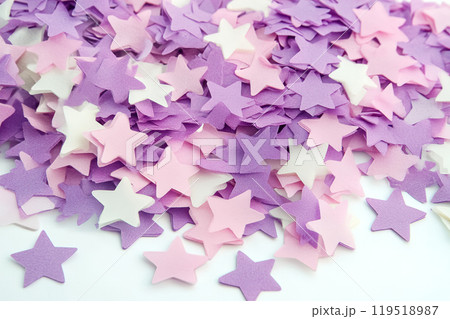 Colorful star-shaped confetti scattered on a white surface, perfect for celebrations, parties, or 119518987
