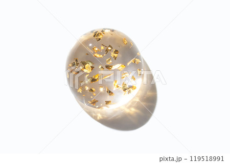 Transparent gemstone with gold flakes on white background showcasing elegant 119518991