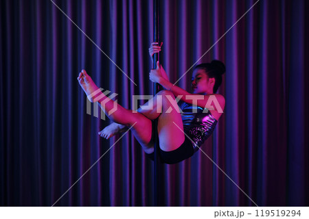 Performing Graceful Aerial Routine on Dance Pole Performing Graceful Aerial Routine on Dance Pole 119519294