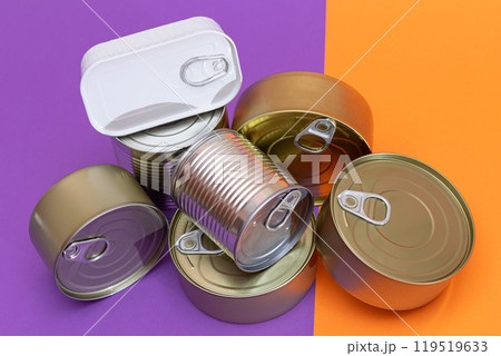 A Group of Stacked Tin Cans with Blank Edges on Split Orange and Violet Background A Group of Stacked Tin Cans with Blank Edges on Split Orange and Violet Background 119519633