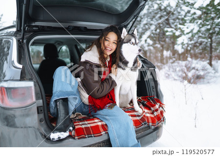 Young woman and cute husky dog enjoying outdoors into the car. Travel concept. Winter season. 119520577