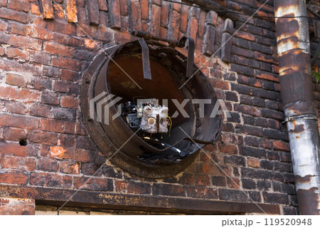 piece of contemporary art in an abandoned factory, a mechanical cat hiding in a pipe 119520948