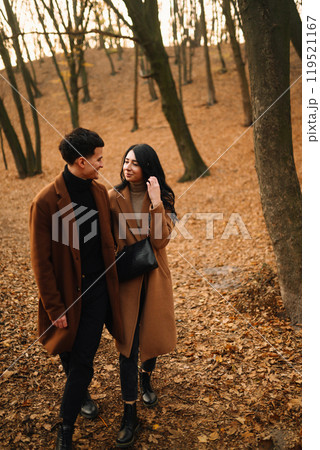 Young couple in love walking in the park on a autumn day. Enjoying time together. 119521167