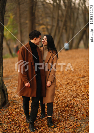 Young couple in love walking in the park on a autumn day. Enjoying time together. 119521172