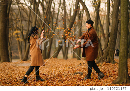 Young couple in love walking in the park on a autumn day. Enjoying time together. Young couple in love walking in the park on a autumn day. Enjoying time together. 119521175