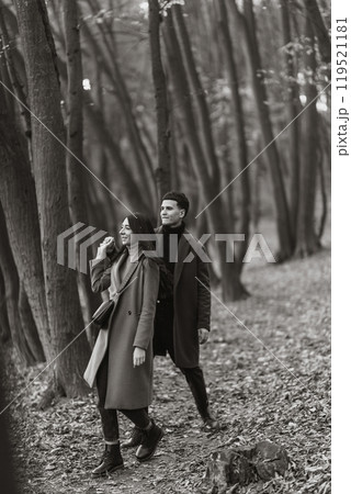 Young couple in love walking in the park on a autumn day. Enjoying time together. Young couple in love walking in the park on a autumn day. Enjoying time together. 119521181