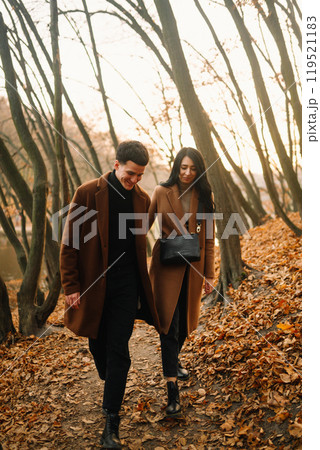Young couple in love walking in the park on a autumn day. Enjoying time together. 119521183