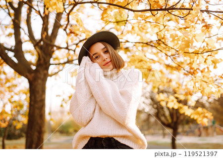 Sunny lifestyle portrait of young stylish woman walking on park, wearing cute trendy hat. Fashion concept. Sunny lifestyle portrait of young stylish woman walking on park, wearing cute trendy hat. Fashion concept. 119521397
