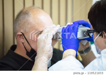 Optometrist picks up glasses for the patient. 119521833