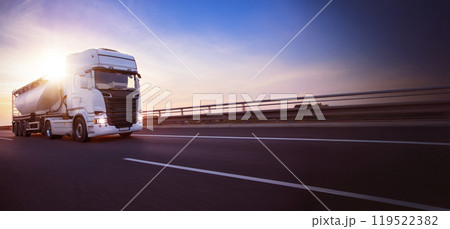 European truck driving on the asphalt road in rural landscape at sunset 119522382