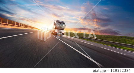 European truck driving on the asphalt road in rural landscape at sunset 119522384