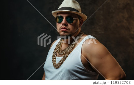 A man wears a stylish hat, cool sunglasses, and a chain 119522708