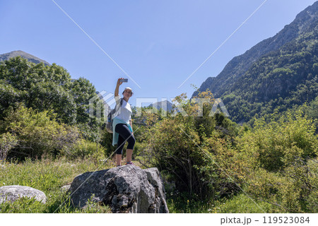 Young pretty tourist woman with backpack take a picture with mobil in the mountain 119523084