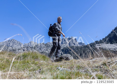 Young pretty tourist man with backpack walking in the mountain 119523085
