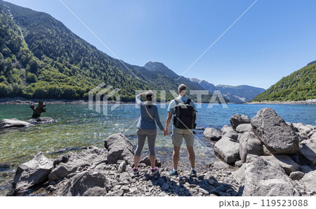 Tourist couple looking at the lake of mountain Pyrenees in Catalonia of Spain 119523088