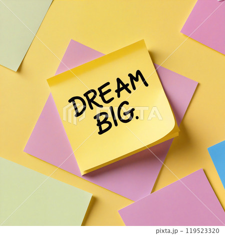Yellow sticky note with dream big handwriting on yellow background 119523320