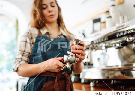 Woman bartender prepares a drink using a coffee machine in a cafe. Takeaway food. 119524074