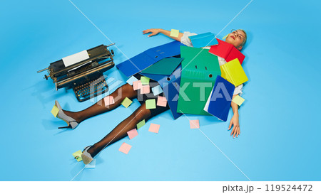 Businesswoman collapsed under office folders. Woman covered with sticky notes, lying on floor under many colorful folders. 119524472