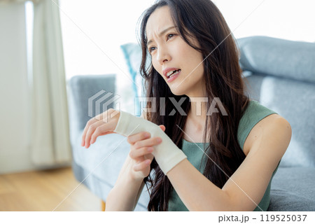 手首にサポーターを巻いている女性 119525037