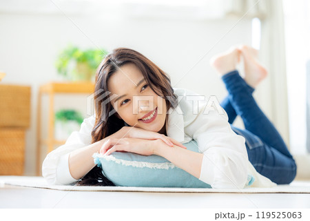 リビングで寝転ぶ笑顔の若い女性 119525063