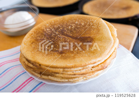 Process of baking pancakes in pans on kitchen stove. stack of hot pancakes Process of baking pancakes in pans on kitchen stove. stack of hot pancakes 119525628