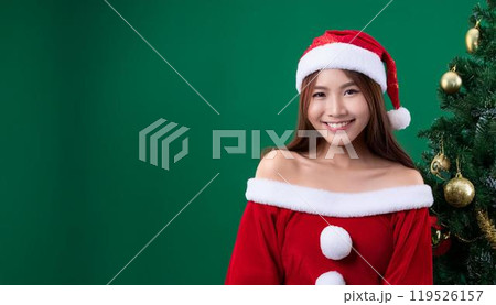 サンタクロースの衣装を着ている若い女性とクリスマスツリー。 119526157