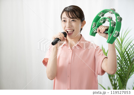 タンバリンを持ってカラオケを歌う女性 119527053