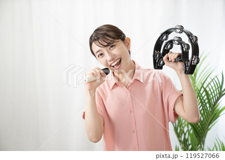 タンバリンを持ってカラオケを歌う女性 タンバリンを持ってカラオケを歌う女性 119527066