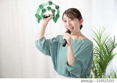 タンバリンを持ってカラオケを歌う女性 119527255