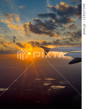 Spectacular Sunset View From an Airplane Wing Over Scenic Landscapes During Evening Flight 119527349