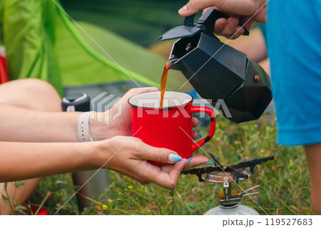 Brewing delicious coffee in the great outdoors, sharing precious moments around a warm campfire with friends Brewing delicious coffee in the great outdoors, sharing precious moments around a warm campfire with friends 119527683