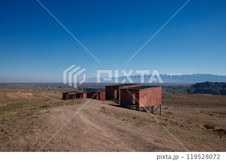 Isolated desert lodging: Modern wooden structures on hillside with panoramic views Isolated desert lodging: Modern wooden structures on hillside with panoramic views 119528072