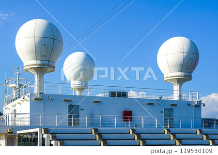 White satellite communication equipment domes on large cruise ship deck 119530109