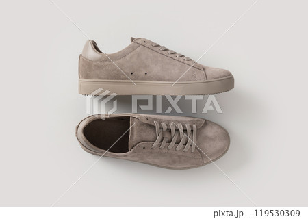 Leather nubuck gray men's sneakers on light gray background. Flat lay. View from above. Copy space. Men's sports casual shoes. Fashionable sneakers. 119530309