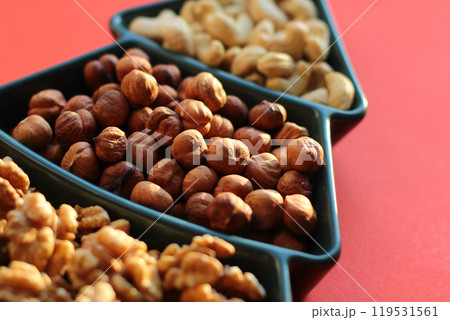 different types of nuts, Various snacks for the New Year table in a plate in the shape of a Christmas tree. different types of nuts, Various snacks for the New Year table in a plate in the shape of a Christmas tree. 119531561