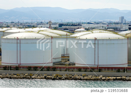 White tanks in tank farm, big silos, tall metal tanks, multiple steel tanks to storage oil products White tanks in tank farm, big silos, tall metal tanks, multiple steel tanks to storage oil products 119531688