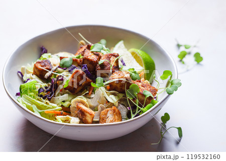 Crispy tofu salad with cashews and sprouts. 119532160