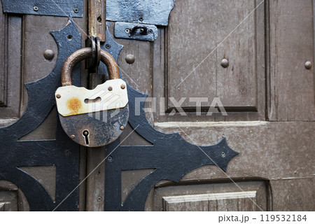 A rusty padlock that features a keyhole located in the middle 119532184