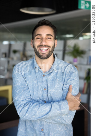 Cheerful positive handsome Hispanic entrepreneur man laughing at camera 119532309