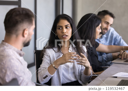 Serious beautiful young Indian professional woman talking to colleague 119532467