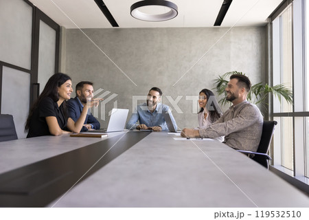 Happy multiethnic business colleagues meeting at large grey office table Happy multiethnic business colleagues meeting at large grey office table 119532510
