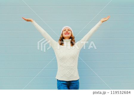 Happy smiling woman having fun raised hands up over blue background Happy smiling woman having fun raised hands up over blue background 119532684